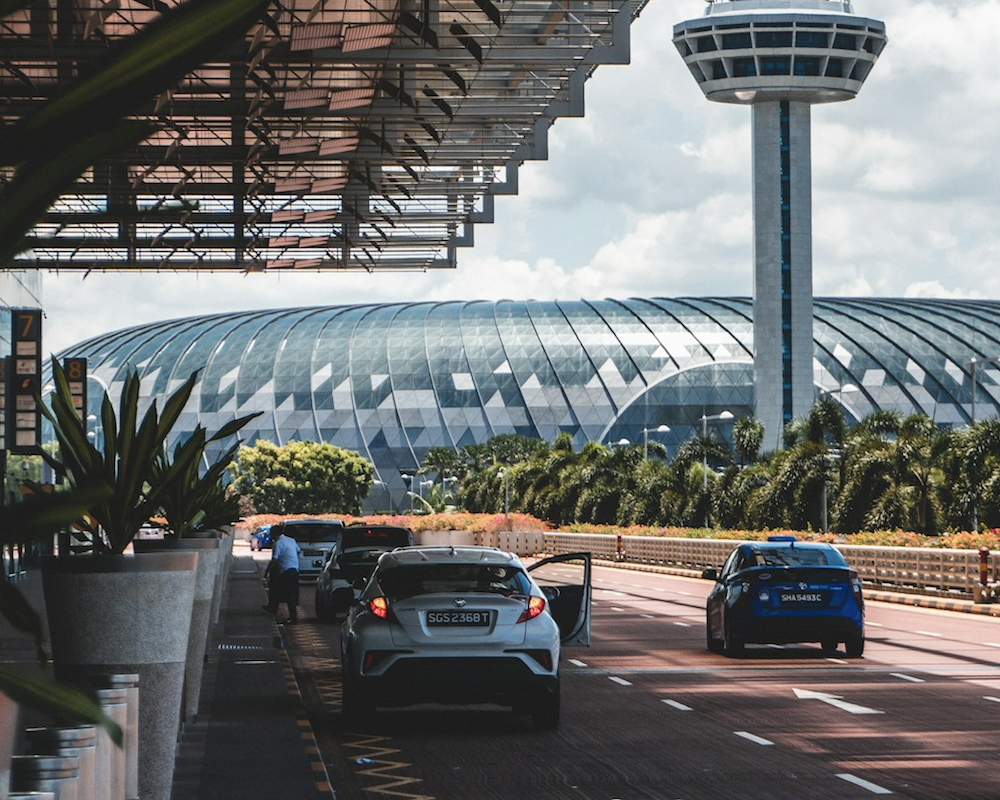 Cars parked outside an airport drop-off area.