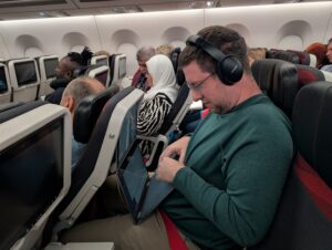 Photo of JT Genter trying to work on a laptop in Turkish Airlines economy