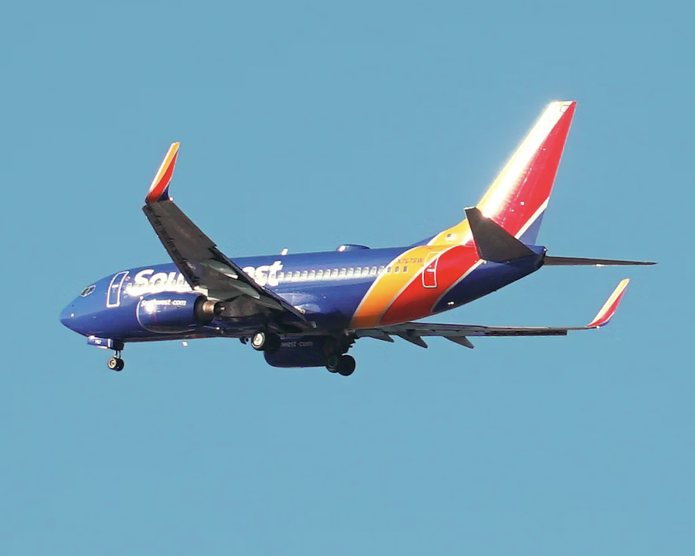 Southwest Airlines 737 taking off under a blue sky background.