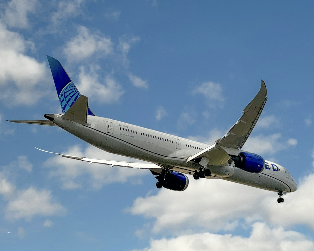 United 787 landing in blue, cloudy skies.