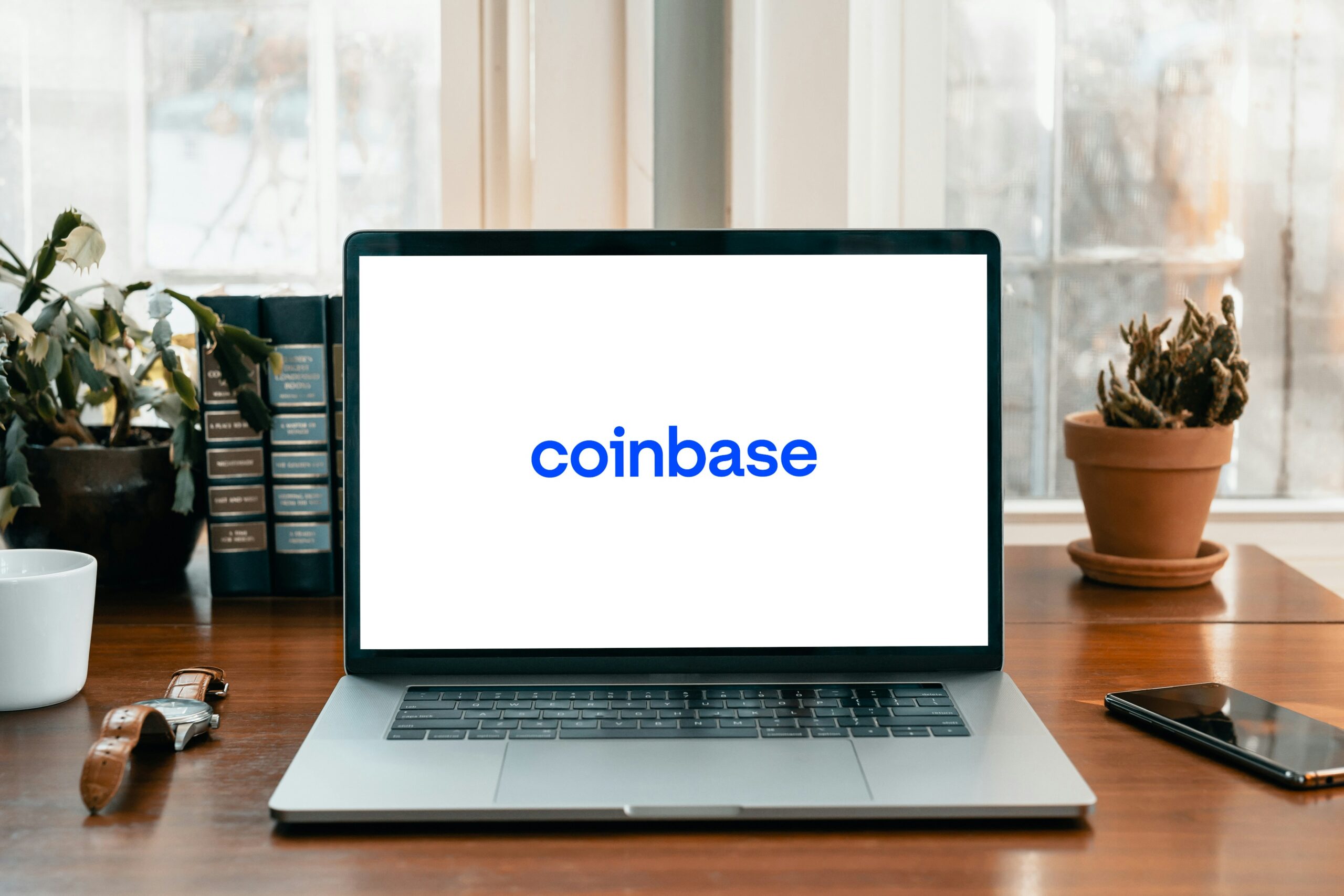 A laptop on a table with Coinbase on the screen
