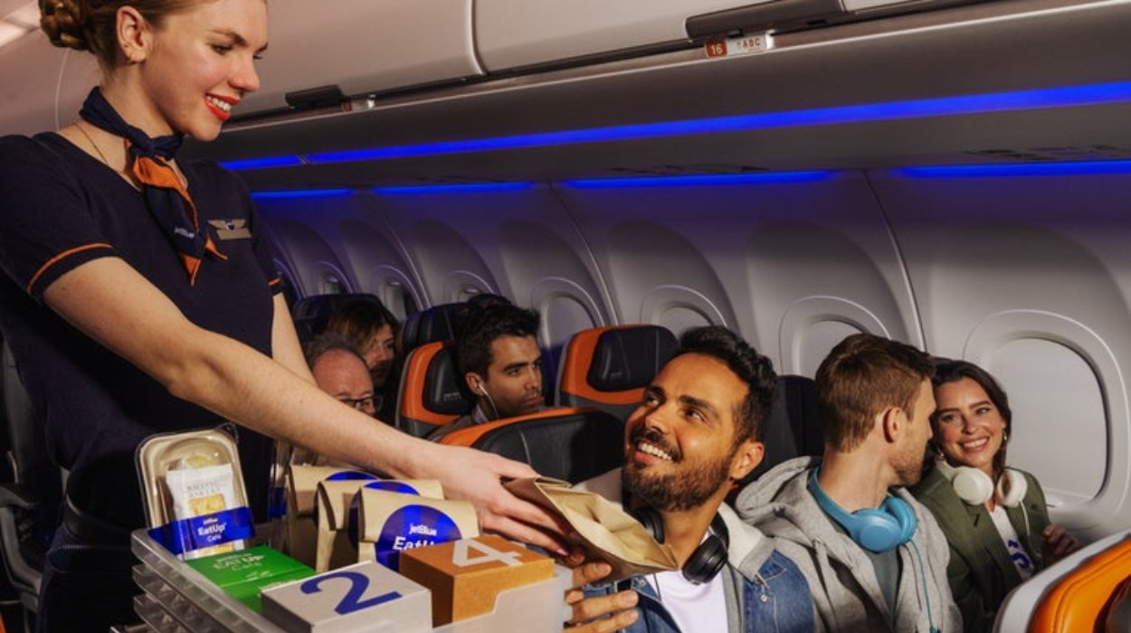 A flight attendant interacting with a passenger aboard a JetBlue flight