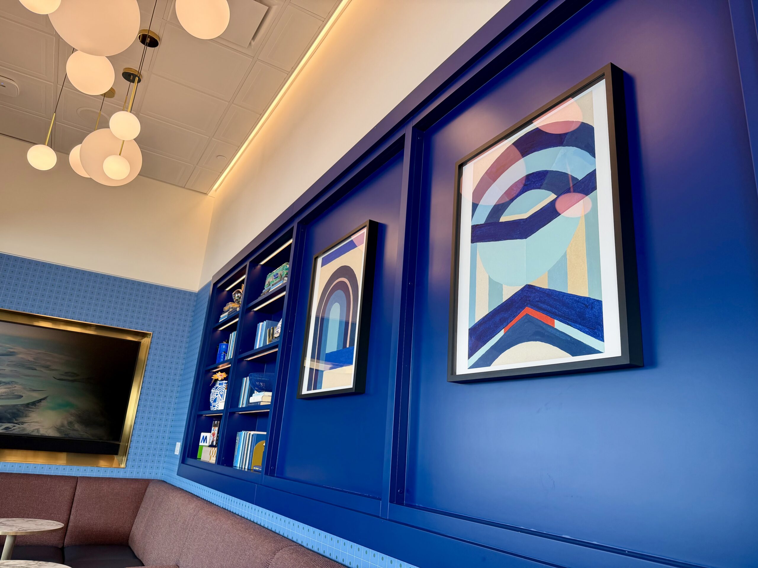 JFK BlueHouse lounge seating area and artwork.