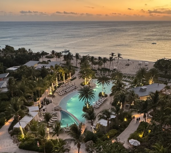 A photo of the Kimpton Seafire's pool and beach from a balcony at sunset.