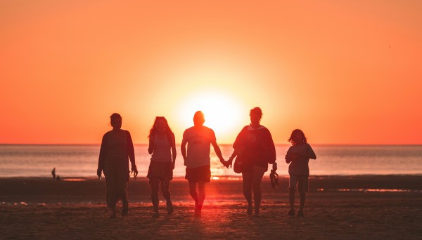A sunset photo of a family on a beach