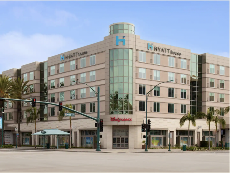 Exterior of the Hyatt House Anaheim Resort, tan building with hotel room windows
