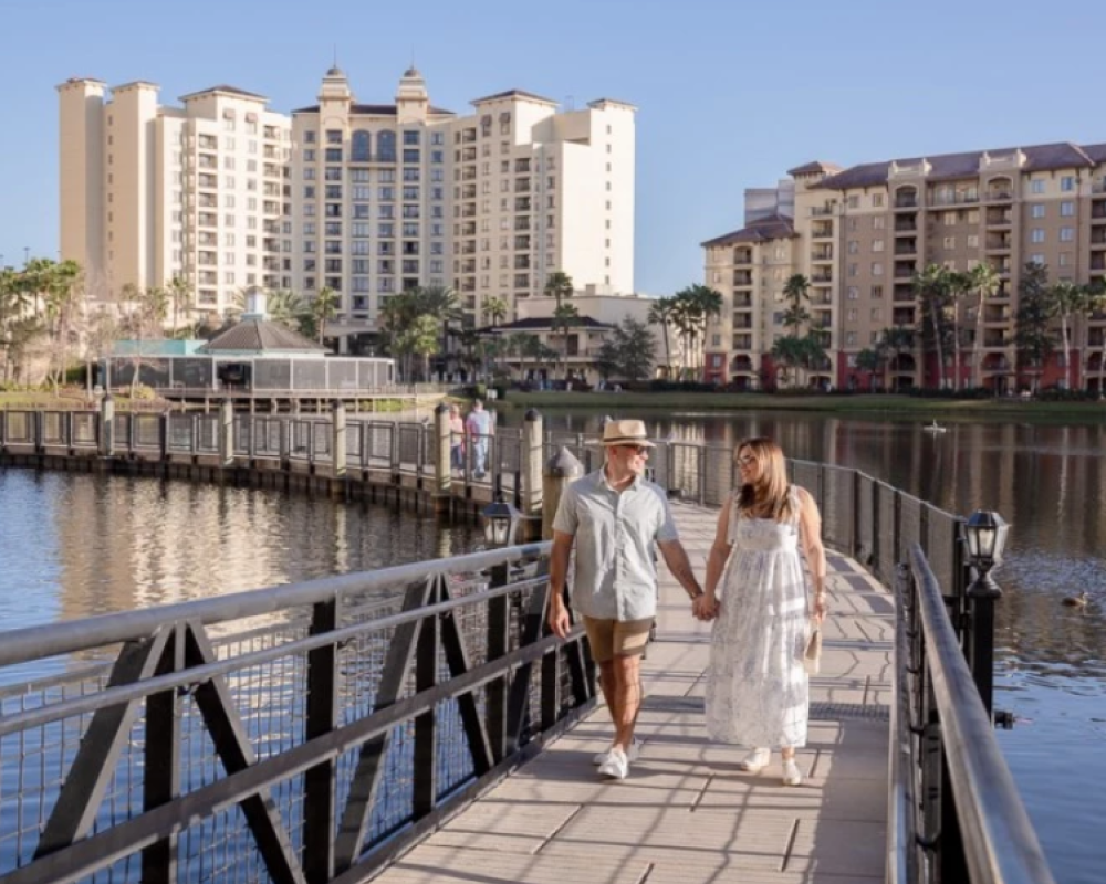 A couple is strolling on a bridge by the Wyndham Bonnet Creek Resort