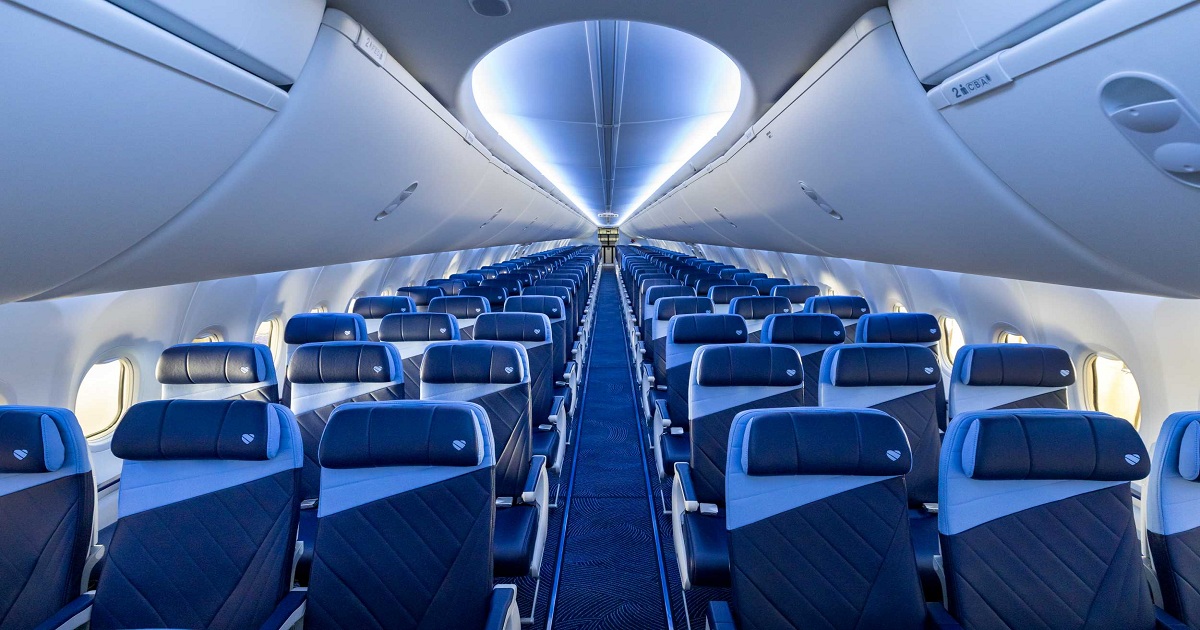 Interior of a Southwest Airlines aircraft with its updated cabin design, featuring blue seats in a 3-3 configuration along a center aisle.