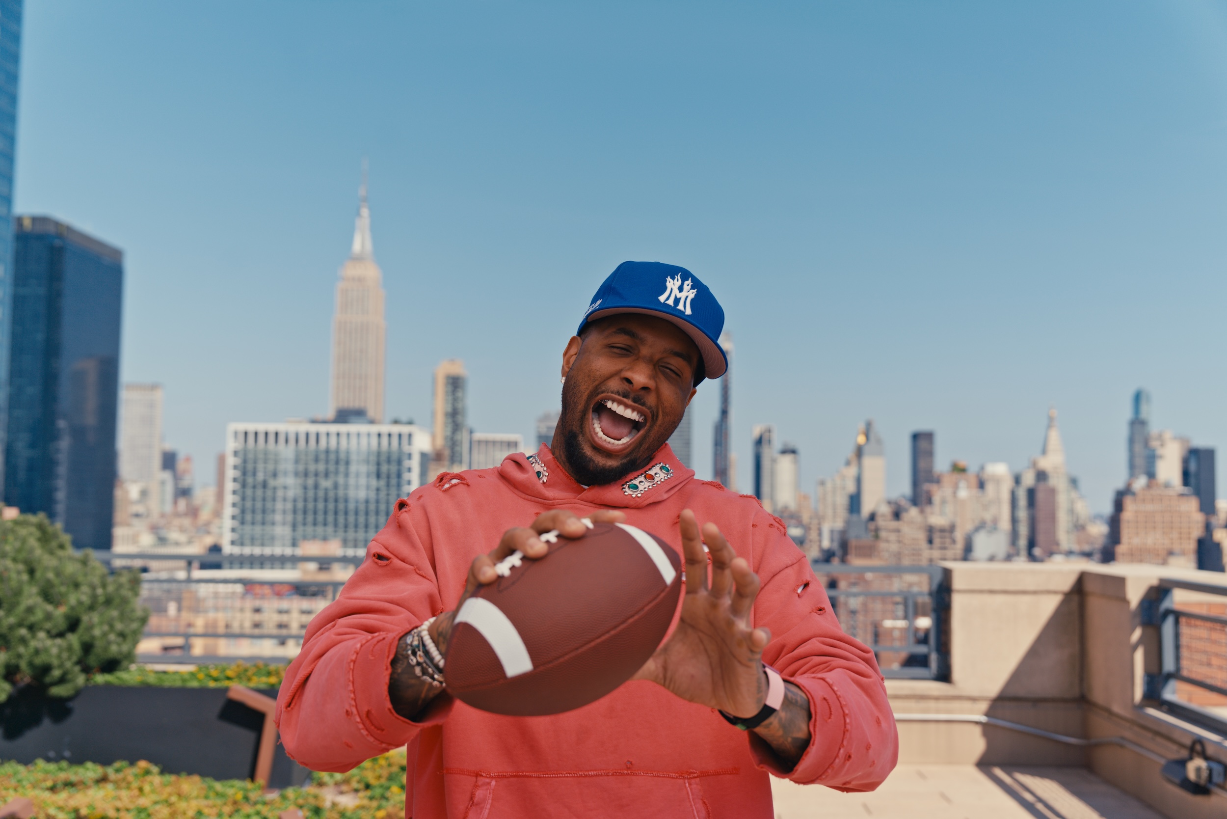 Odell Beckham Jr. holding a football in front of the New York skyline