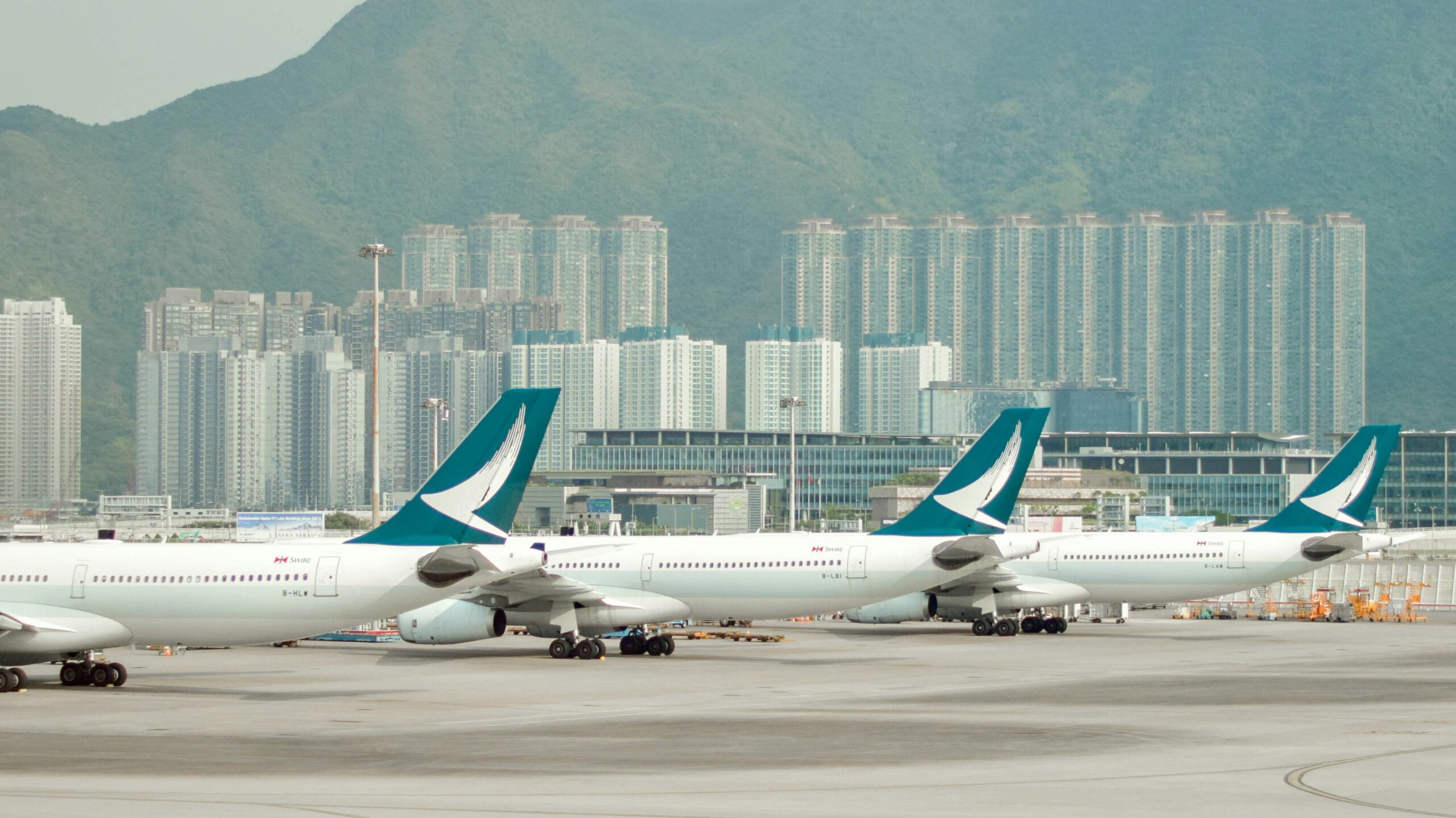 Three Cathay Pacific planes sitting at HKG airport
