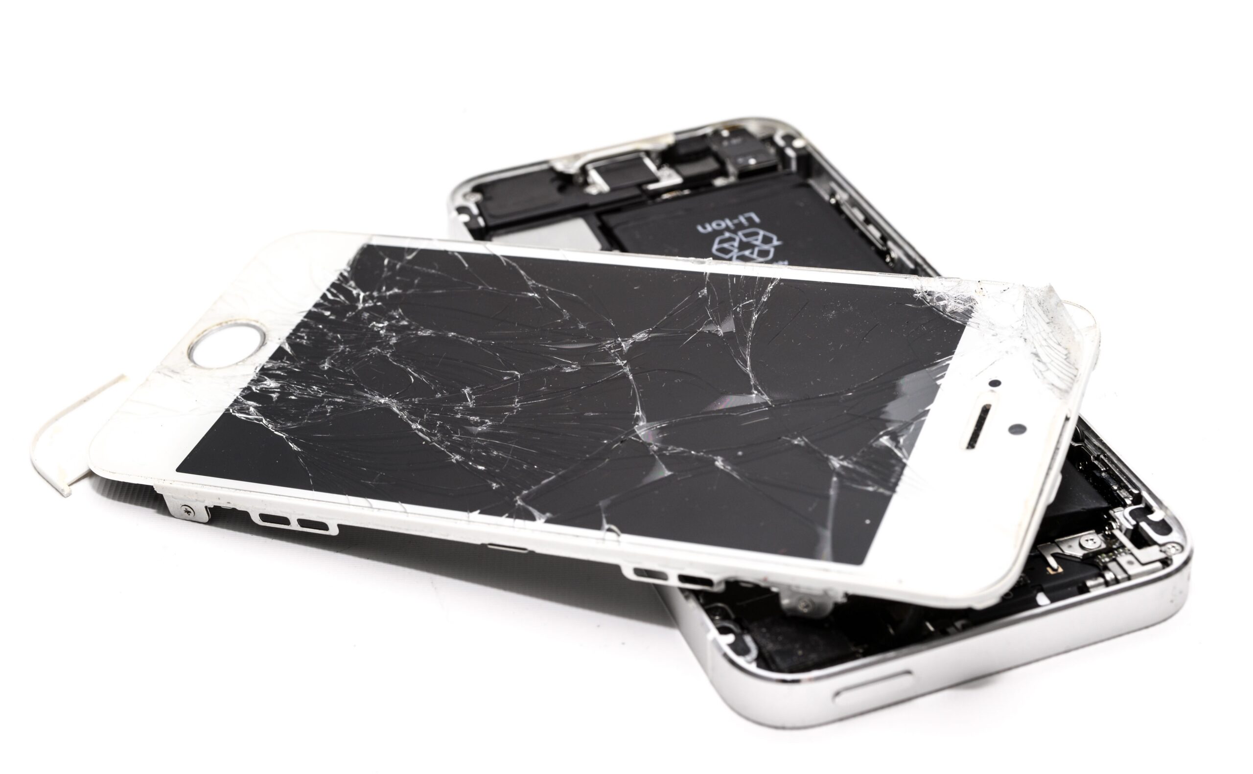 An iPhone with a shattered screen hanging off the base