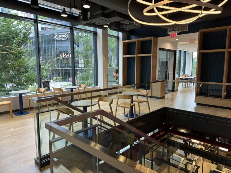 A coffee shop with warm lighting and tables and chairs.