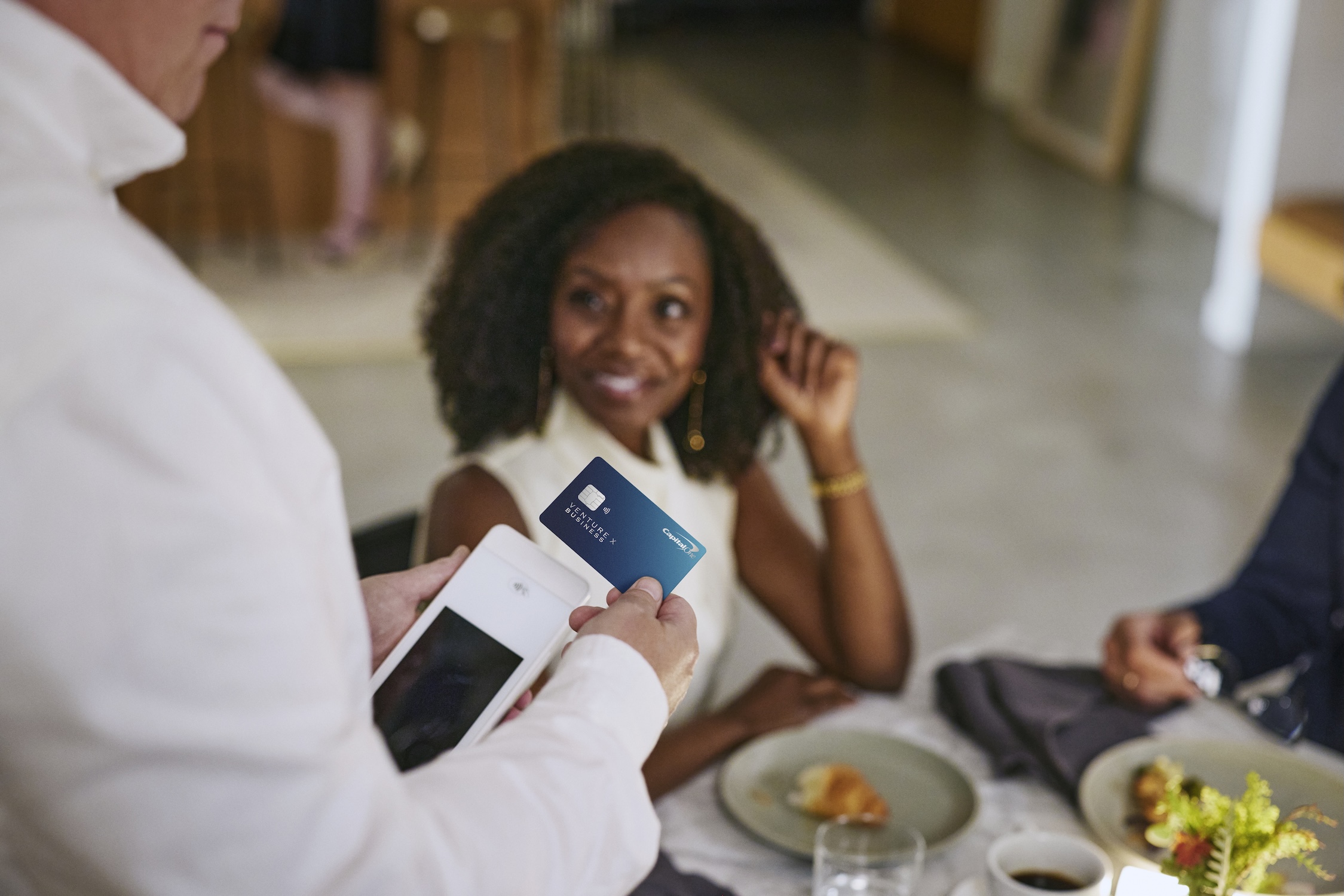 A waiter using the Venture X Business to tap to pay