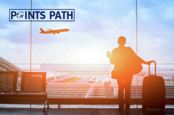 A person is looking out of an airport window at a plane taking off, with sunset colors. The Logo for Points Path is in upper left corner.