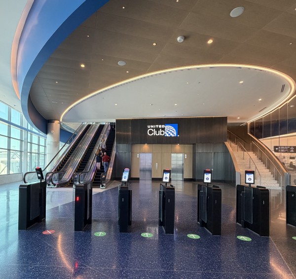 THe united Club Entrance at IAH's Terminal B. There are two escalators on the left and six entry gates.