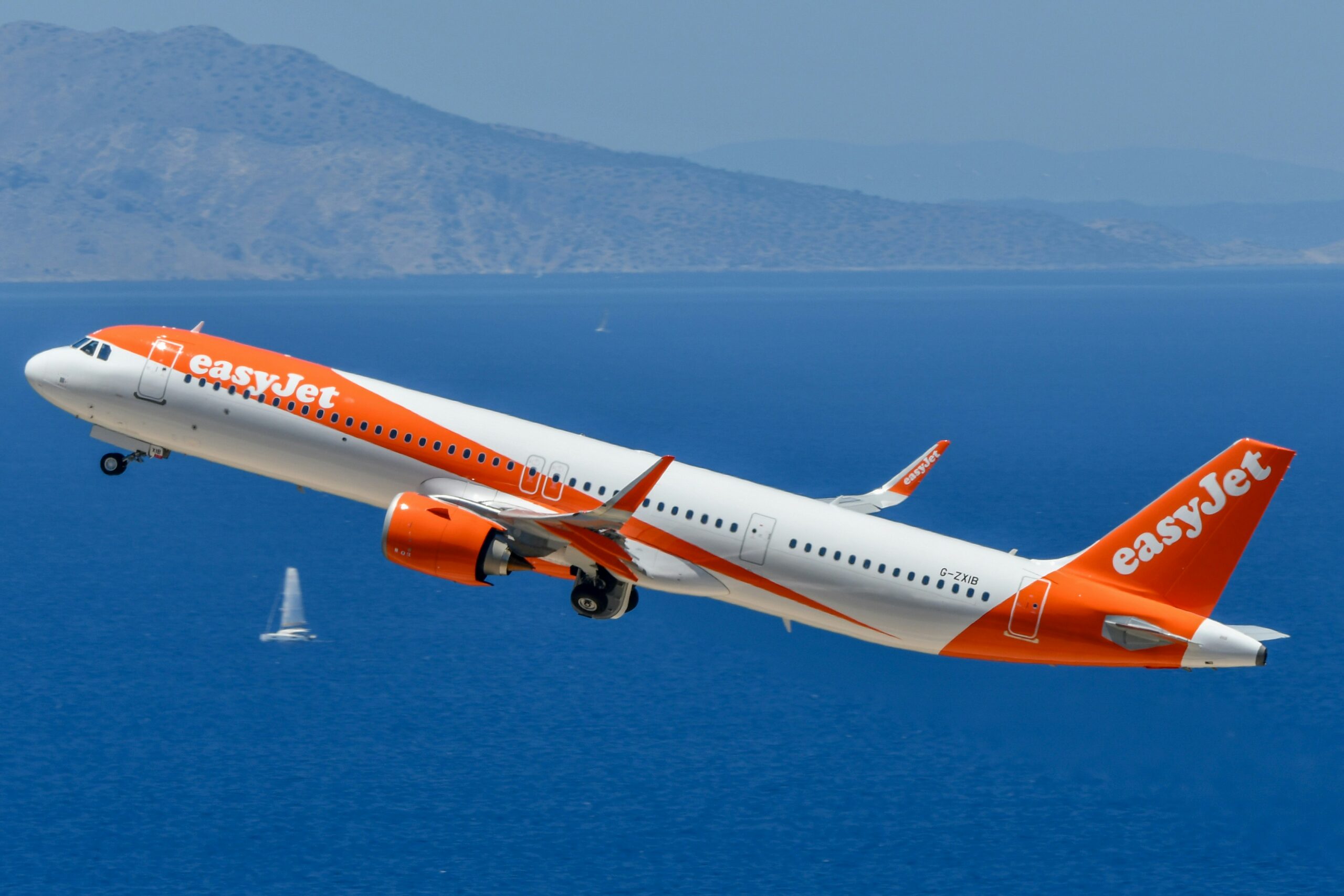 EasyJet plane taking off above a body of water